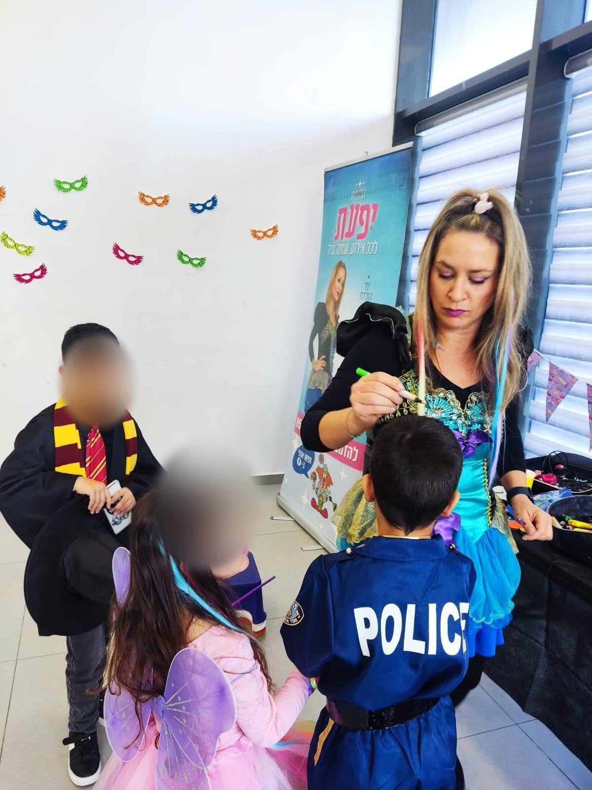 יפעת מציירת על הפנים של ילדים בתחפושות באירוע